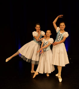 Three teenage ballerinas in white villager style tutus. Dancers are on stage at Queenstown Memorial Centre